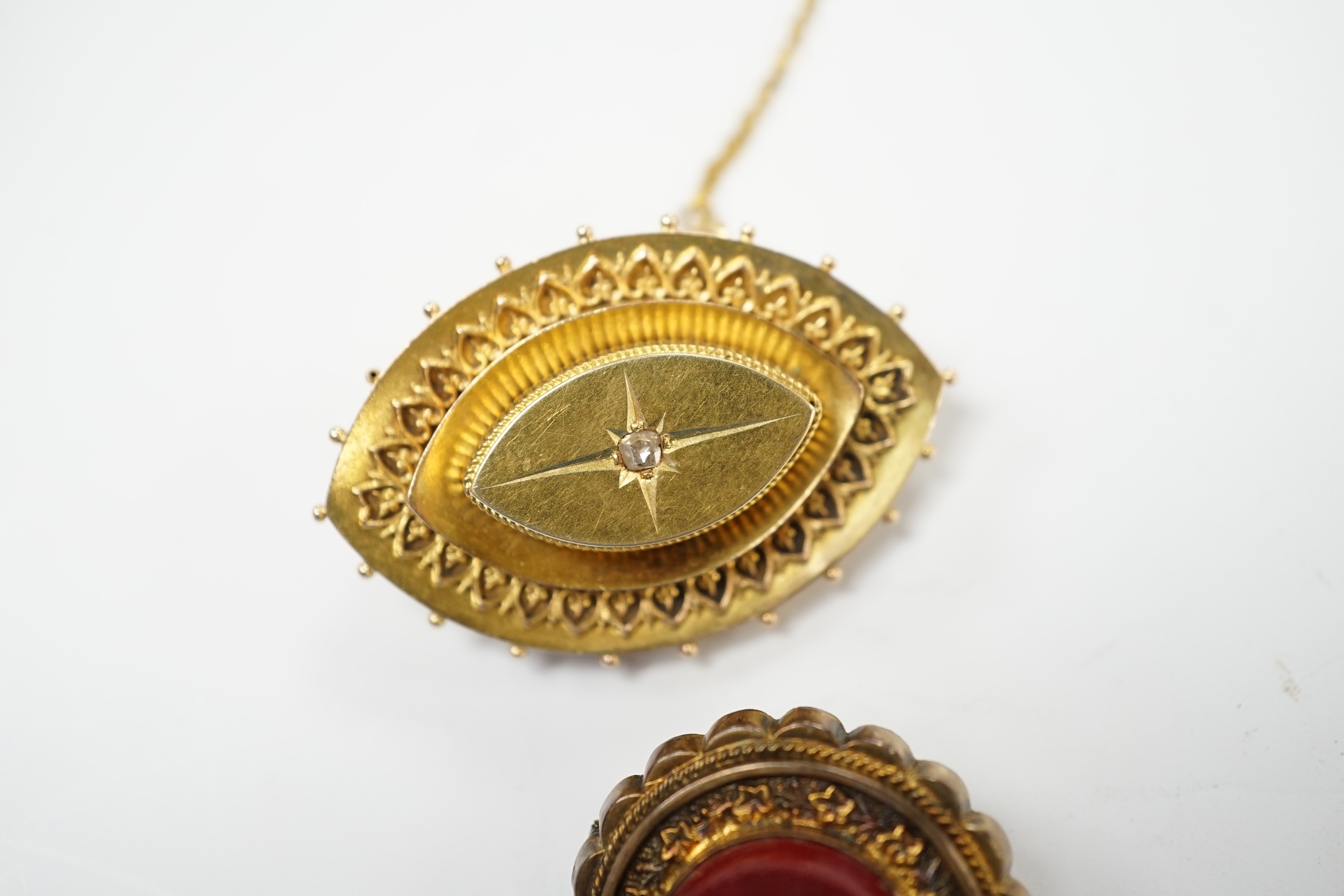 A Victorian yellow metal and diamond chip set navette shaped brooch, 39mm and a gilt metal and micro mosaic set circular brooch. Fair condition.